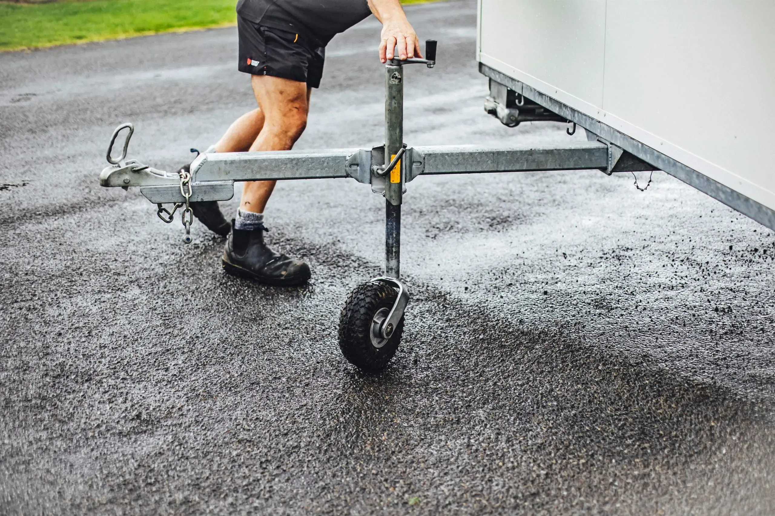A man is seen pulling a trailer that has one wheel, indicating a simple yet effective way to move items