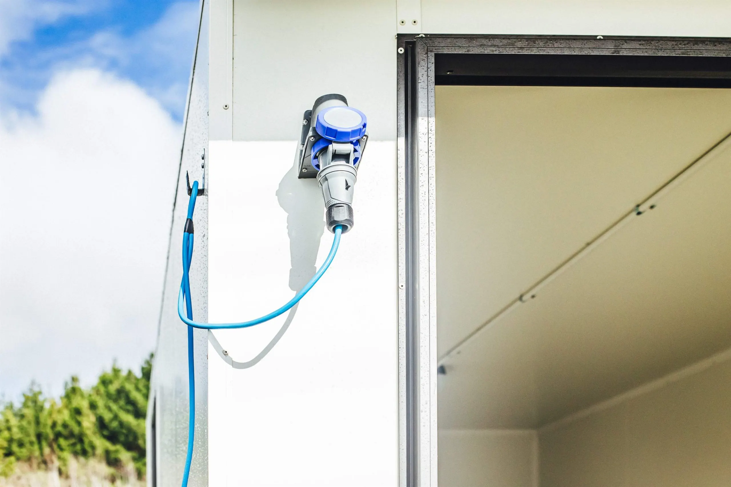 A hose connected to a white trailer, for water or fluid transfer