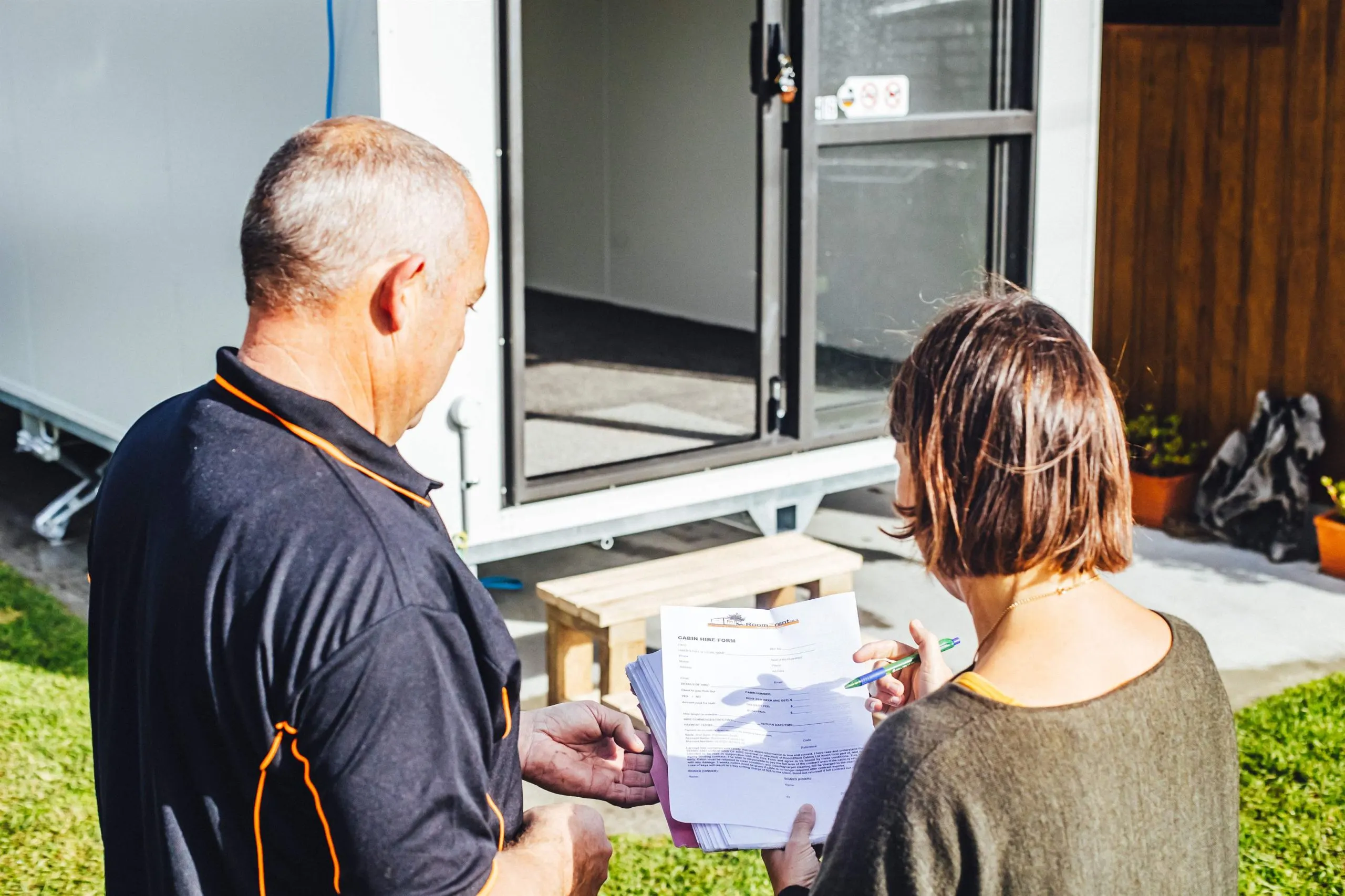 man and woman stand together in front of a Room2Rent