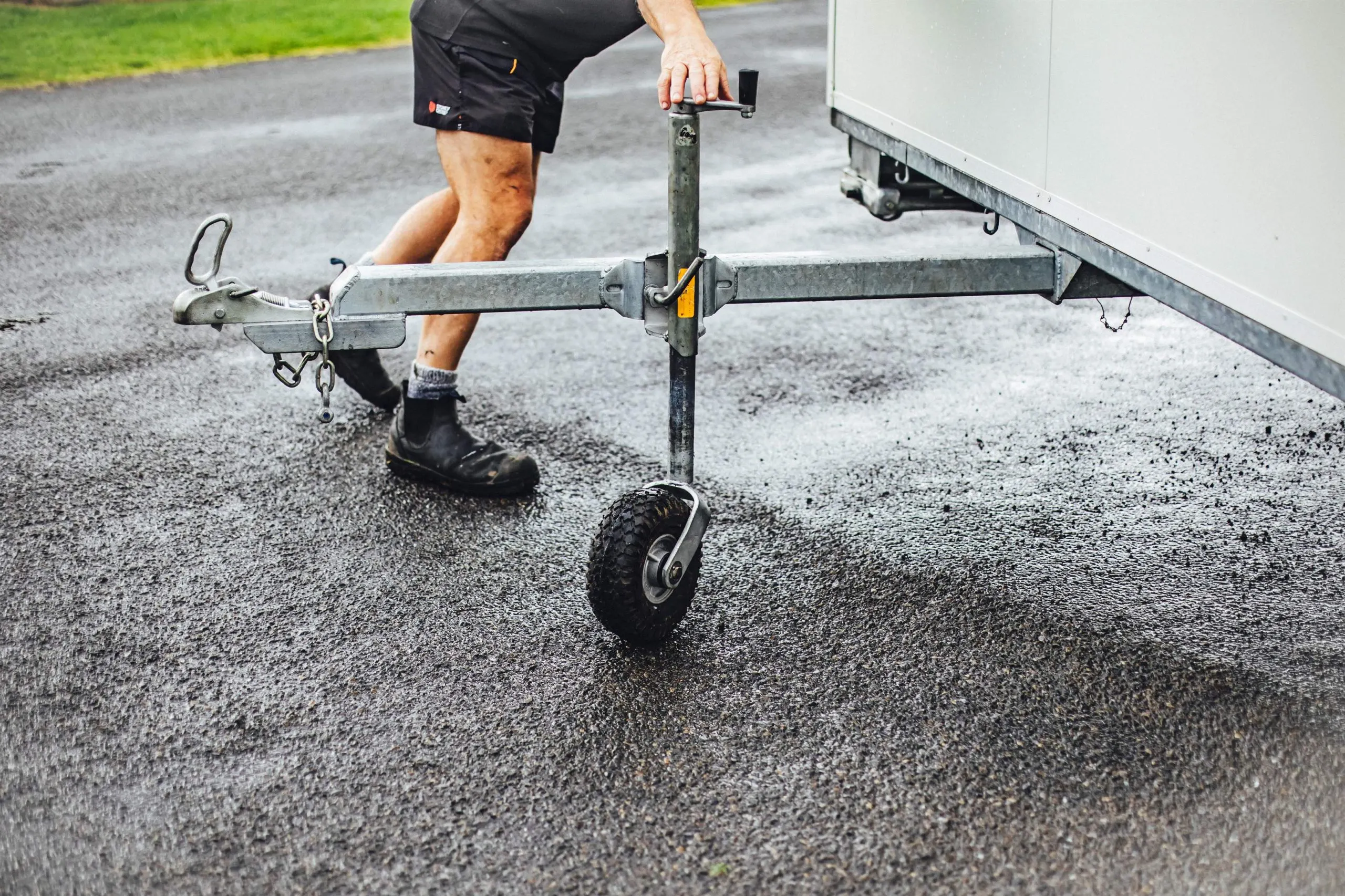 A man is seen pulling a trailer that has one wheel, indicating a simple yet effective way to move items