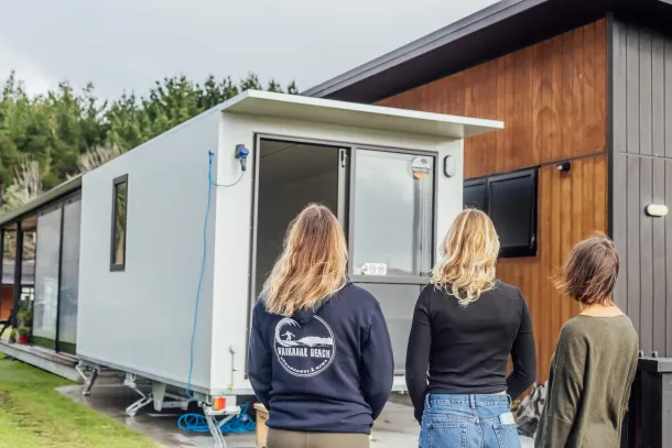 three individuals is gathered outside a mobile home, enjoying a casual moment together in the fresh air